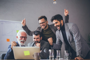 A team of experts celebrating their business success in an office.