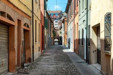 Fototapeta na wymiar Narrow medieval street in Ferrara, Italy