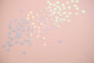Pink background with pastel star shape confetti sparkles. Festive background.