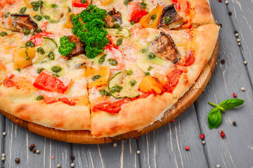 Traditional italian pizza with grilled vegetables on wooden background