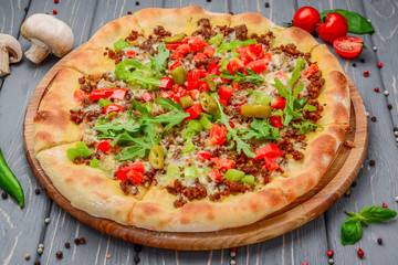 Traditional italian pizza with minced meat on wooden background