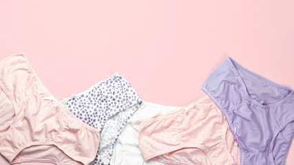 Set of female panties on pink background. Pastel colors fashion flat lay. Space for text.