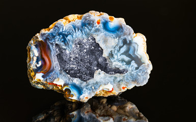 Beautiful hollow agate semi-precious stone with clear raw crystals inside geode. One natural chalcedony with blue colored cut surface and crystalline crystal in cavity detail. Quartz of north Bohemia.