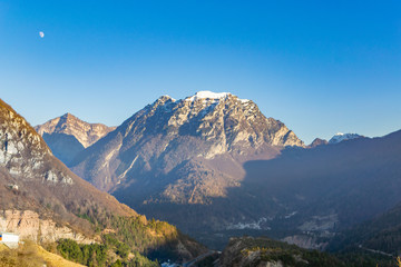 Obraz premium The moon over the mountains in Dolomites Alps, Italy