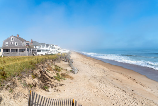 Foggy beach lined with hoday homes along the coast of New Hampshire in autumn