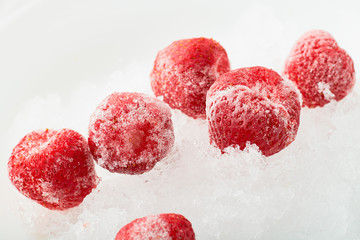 Several frozen strawberries on ice: concept of freezing foods