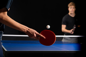 Table tennis ping pong paddles and white ball on blue board