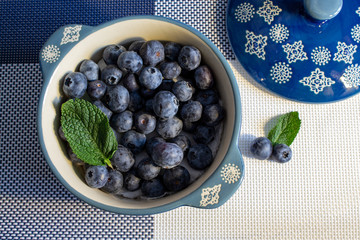Juicy blueberries in a blue cup