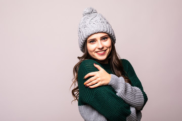 Beautiful young woman in warm clothing on white background