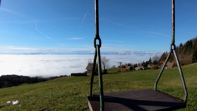 Left truck moving kids swing equipment on hilltop with view on village and low altitude fog