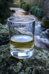 Scotch single malts or blended whisky spirits in glasses with water of river Spey on background, Scotland