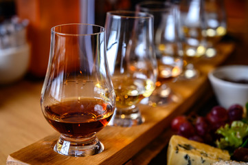 Scotch whisky, tasting glasses with variety of single malts or blended whiskey spirits on distillery tour in Scotland