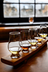Scotch whisky, tasting glasses with variety of single malts or blended whiskey spirits on...