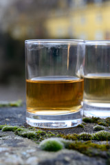 Scotch single malts or blended whisky spirits in glasses with old houses of Edinburgh on background, Scotland, UK