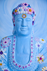 face of happy buddah in blue with colorful decoration