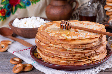 Big stack of thin pancakes with honey. Russian bliny. Maslenitsa.