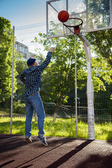 boys playing basketball outdoors on a sports field