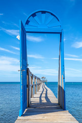 Beautiful blue door on the beach of Sandy Bay on the Roatan Island of the Caribbean Sea, vertical photo. Honduras