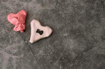 Festive background for Valentine's Day on a gray cement background with hearts in retro style from plasticine.