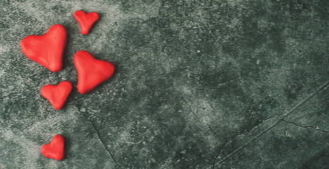 Festive background for Valentine's Day on a gray cement background with hearts in retro style from plasticine.