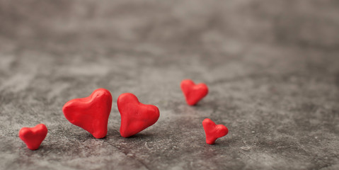 Obraz premium Festive background for Valentine's Day on a gray cement background with hearts in retro style from plasticine.