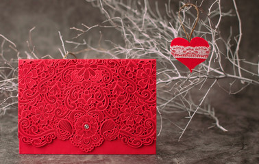 Holiday background for Valentine's Day on a gray cement background with white painted branches and a sheet of paper for text