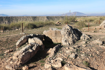  landscape with stones of ancient megalithic burial construction dolmen in Gorafe badlands, Spain and blue sky