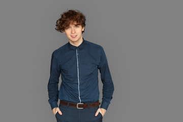 Freestyle. Teenager boy standing isolated on grey posing to camera smiling confident