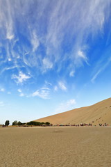 Fototapeta na wymiar Sand climbers on the dunes around Crescent lake-Yueyaquan oasis. Dunhuang-Gansu-China-0681