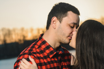 The guy and the girl in the park stand on the ice of the lake on Valentine's day.