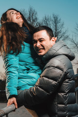 Young beautiful loving couple walking in city park near lake on valentines day.