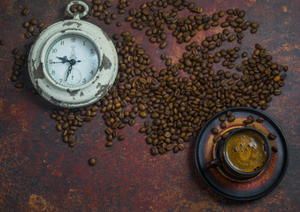 alarm clock and coffee beans on brown background