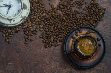 alarm clock and coffee beans on brown background