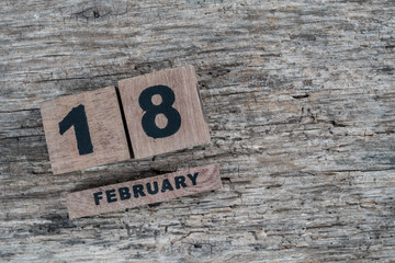 cube calendar for february on wooden background with copy space