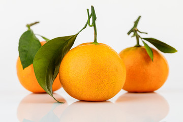 Ripe Mandarin with leaf close-up on white background