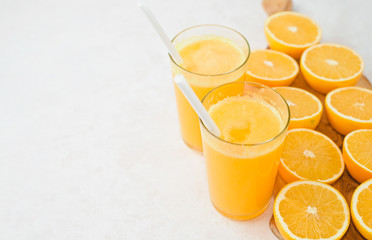 Glass of freshly squeezed orange juice and slices of orange fruit isolated on white background