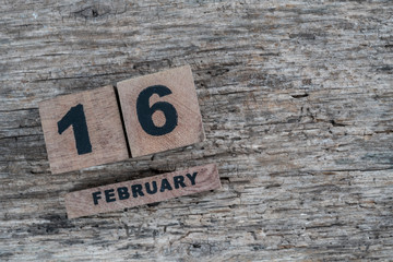 cube calendar for february on wooden background with copy space