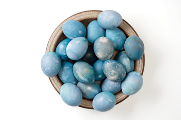 Aquamarine easter eggs in ceramic bowl isolated on white