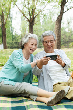 Elderly couple watch mobile phone