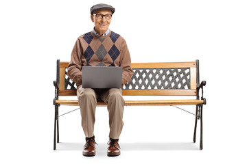 Elderly man working on a laptop and sitting on a bench
