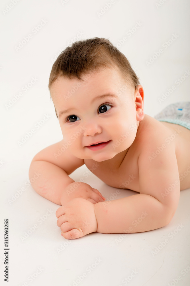 Wall mural portrait of a healthy baby boy, baby looking at the camera smiling, baby 9 months on a white background