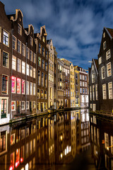 Obraz premium Amsterdam canals and houses against night cityscape of Amsterdam, Holland Netherlands