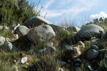 Mountain slope with rocks, wild grass and sky