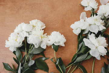 Stylish white peony flat lay on rustic wooden table with space for text. Greeting card mockup. White peonies rural still life, top view. Hello spring image. Happy Mothers day. Womens days