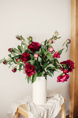  Red and pink peonies rural still life. Stylish peony bouquet in white ceramic vase on linen fabric on rustic wooden background.Hello spring wallpaper. Happy Mothers day. Space text