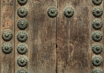 Obraz na płótnie Canvas Rusty old knocker on weathered wooden door Greenish deteriorated door detail