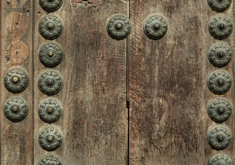 Rusty old knocker on weathered wooden door Greenish deteriorated door detail