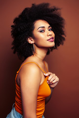 Fototapeta premium pretty young african american woman with curly hair posing cheerful gesturing on brown background, lifestyle people concept