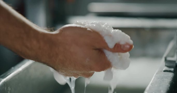 Close up of an artisan papermaking master is working a cellulose in a water for production of high quality handmade paper in a workshop. Concept of handmade,high quality,artisan, tradition