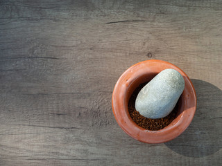 Black coffee ground in a clay mortar on the wooden table, with place for text. Top view.